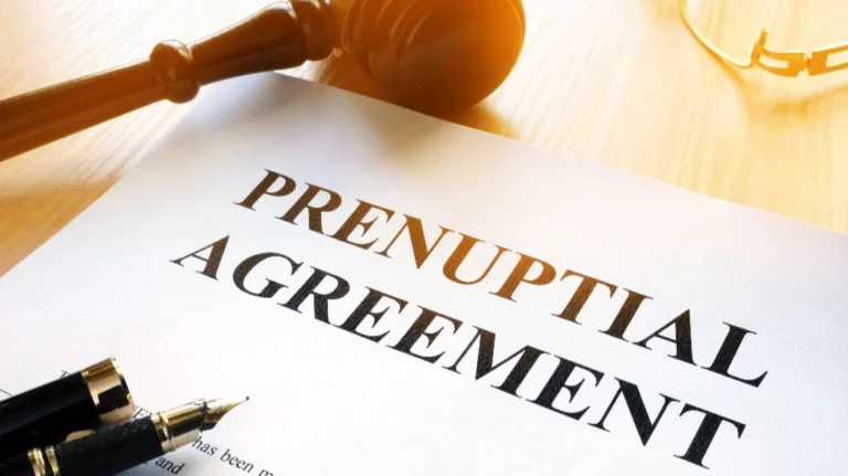 Document titled "Prenuptial Agreement" on a wooden desk with a fountain pen and judge's gavel.