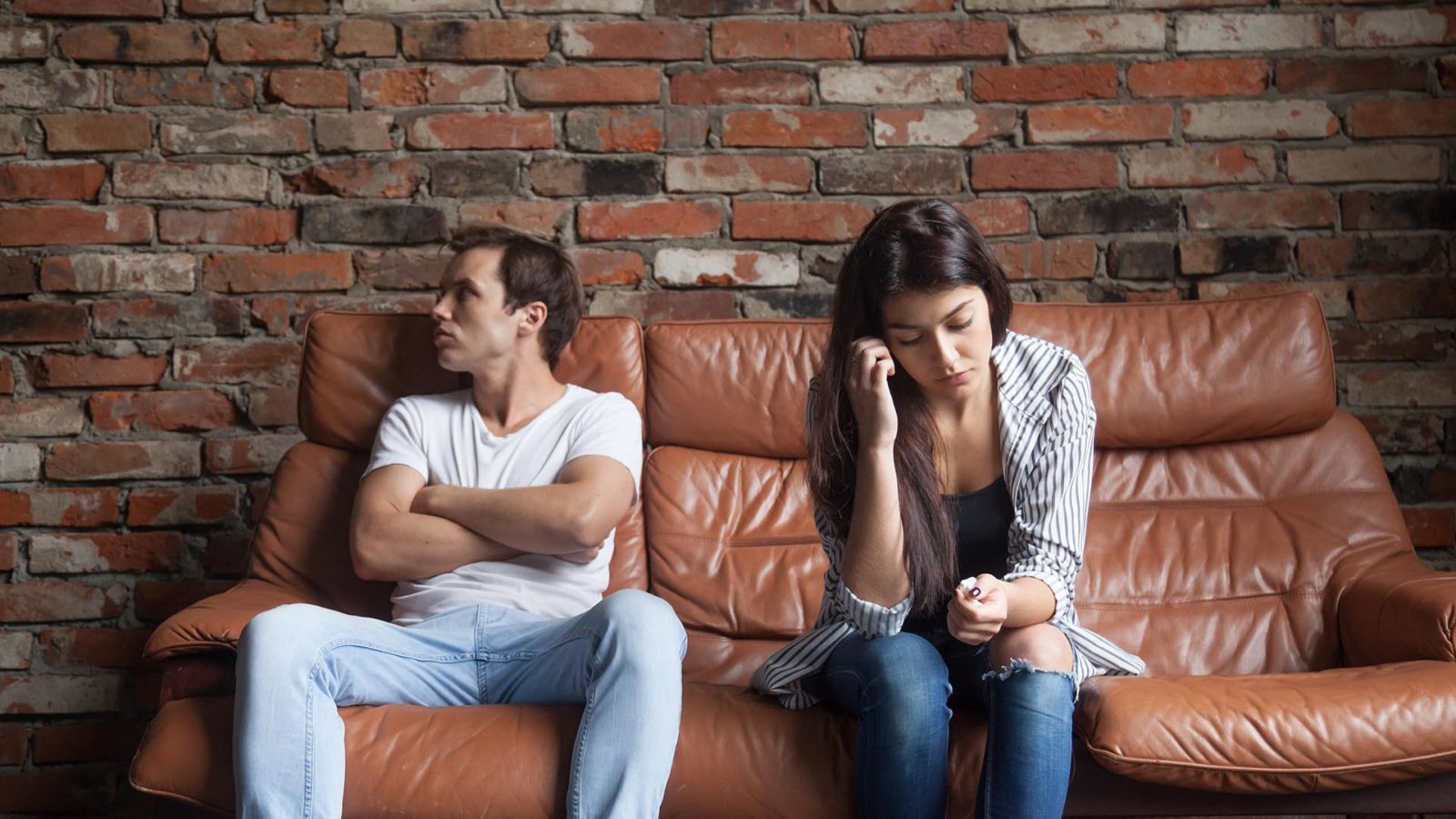 upset couple sitting on a couch