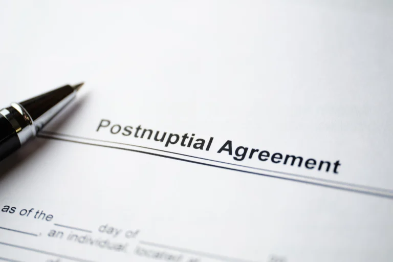 Close-up of a Postnuptial Agreement document with a black pen resting on the paper.